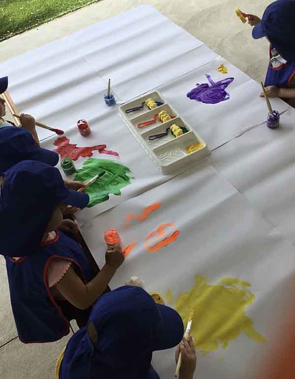 An image of children painting on canvas in early learning childcare centre.