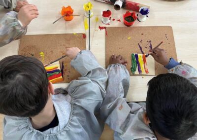 An image of children learning how to paint in childcare centres.