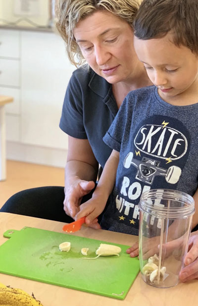 An image of a instructor assisting a child in early childcare centre.
