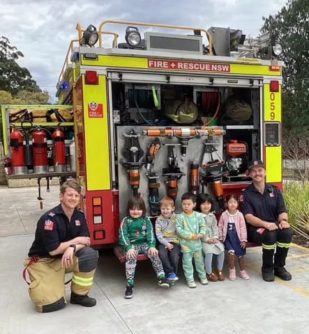 children-developing-confidence-through-play-and-connection Children visiting a fire and rescue truck with community firefighters during an early learning activity